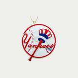 Yankees Christmas Ornament. This Ornament is in the shape of a baseball with Yankees written on it in red, and a baseball bat with a hat on it